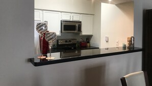 A modern kitchen with white cabinets, a black countertop, and a microwave. - Energy Corridor - long term rental. Utilities included!! (Houston)
