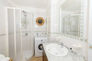 Een bad/douchecombinatie, een haardroger, een bidet, handdoeken