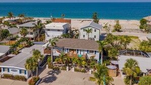 Ein Anwesen direkt am Strand mit mehreren Gebäuden, darunter ein großes Haus mit blauem Dach und ein kleineres Gebäude mit der Aufschrift 'Myrtle Beach Inn'.