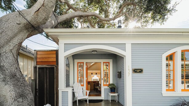 A house with a front porch, a wooden door, and a mailbox.