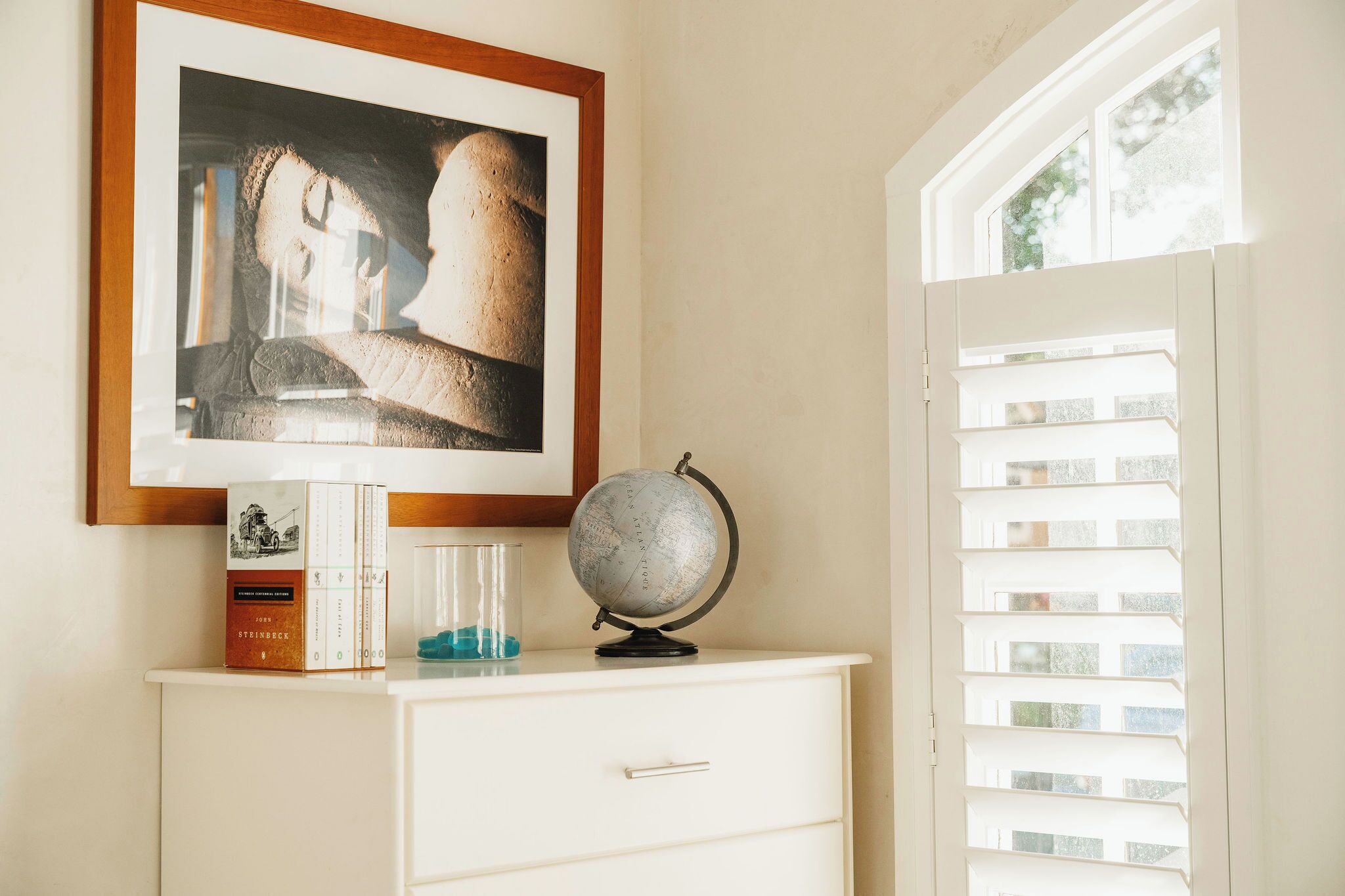 A desk with a framed picture, a globe, and books.