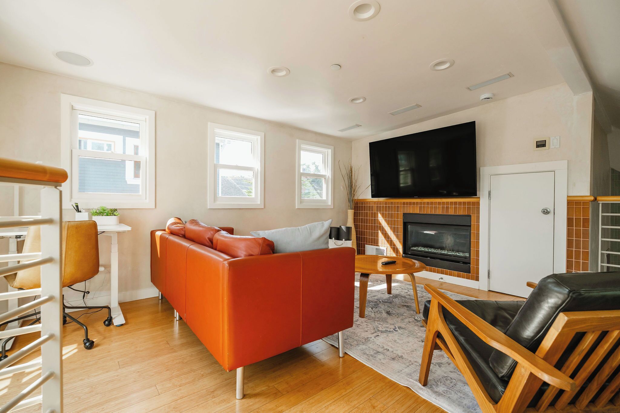 A modern living room with a sofa, a TV, and a fireplace.