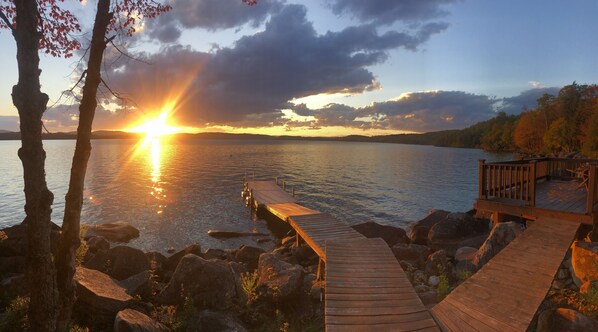 A wooden dock extending into calm water with a sunset in the background. - Peace and tranquility on Sebec Lake (Bowerbank)