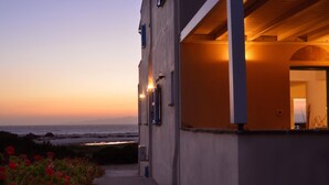 A building with a view of the ocean at sunset. - Breathtaking sunset, salt lake and Aegean sea view. 150m from magnificent beach. (NAXOS)