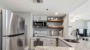 A modern kitchen with stainless steel appliances, a microwave, oven, and a coffee maker.