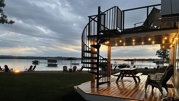 Una terraza con asientos al aire libre y vista al lago al anochecer.
