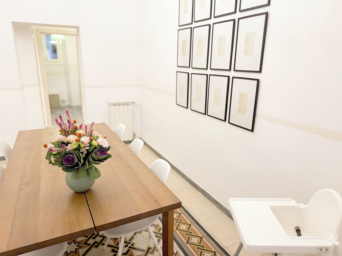 Een vergaderruimte met een houten tafel, witte stoelen, een whiteboard en ingelijste diploma’s aan de muur.
