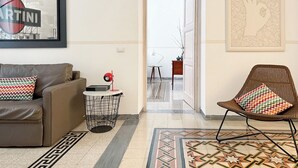 A modern living room with a sofa, a chair, a small side table, and a patterned rug. - Modern Comfort, Poetic Charm (Roma)