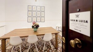 A conference room with a wooden table, white chairs, a chandelier, framed certificates on the wall, and a sign reading "CASA DI LUISA". - Modern Comfort, Poetic Charm (Roma)