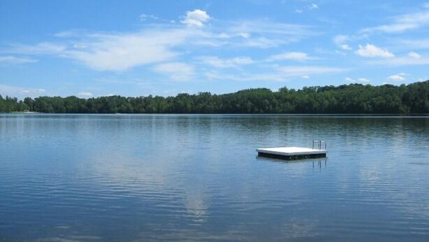 Un lago tranquilo con un muelle que se adentra en el agua.