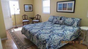 A bedroom with a large bed, two chairs, a small table, and a window with blinds. - Downtown South Haven, close to everything,  family friendly, very clean (South Haven)