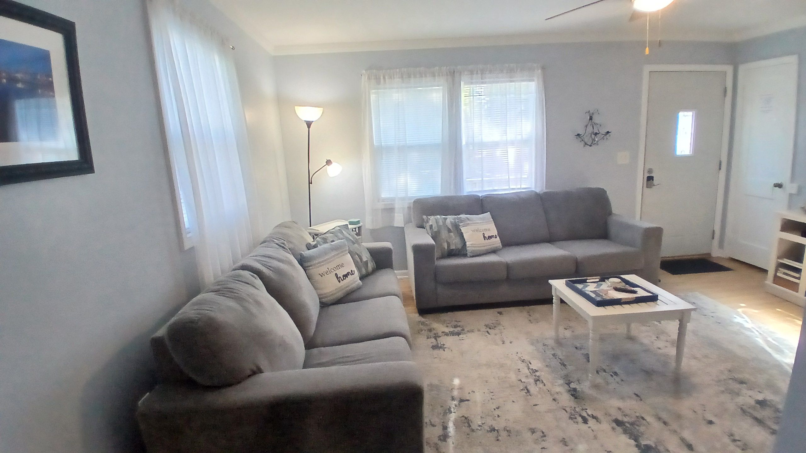 Ein Wohnzimmer mit einer Couch, einem Couchtisch und einer Lampe.