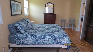 Un dormitorio con cama, cómoda y espejo.