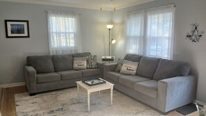 A living room with two grey sofas, a white coffee table, and a floor lamp.