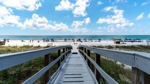 A wooden boardwalk leading to a beach with umbrellas and people. - 4th Newest Beachfront Condo! 100% No Smoking (Panama City Beach)