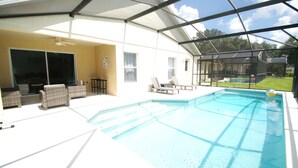 A covered outdoor swimming pool with lounge chairs and a patio area. - Amazing villa - Close to Disneyworld (Clermont)
