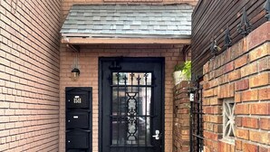 A brick building with a black door, numbered mailboxes, and a small window above the door. - Downtown Suite in Cap Hill ! (Denver)