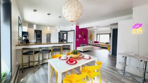 A modern kitchen with a white countertop, yellow chairs, and a hanging light fixture. - Downtown Suite in Cap Hill ! (Denver)