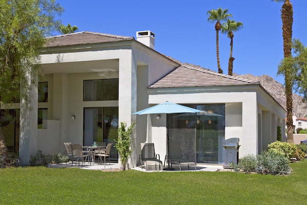 A modern house with a patio, outdoor seating, and a clear view of the surrounding landscape.
