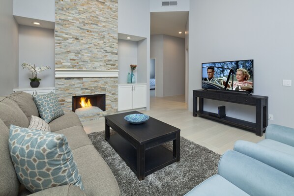 A modern living room with a fireplace, a television, and a sofa.
