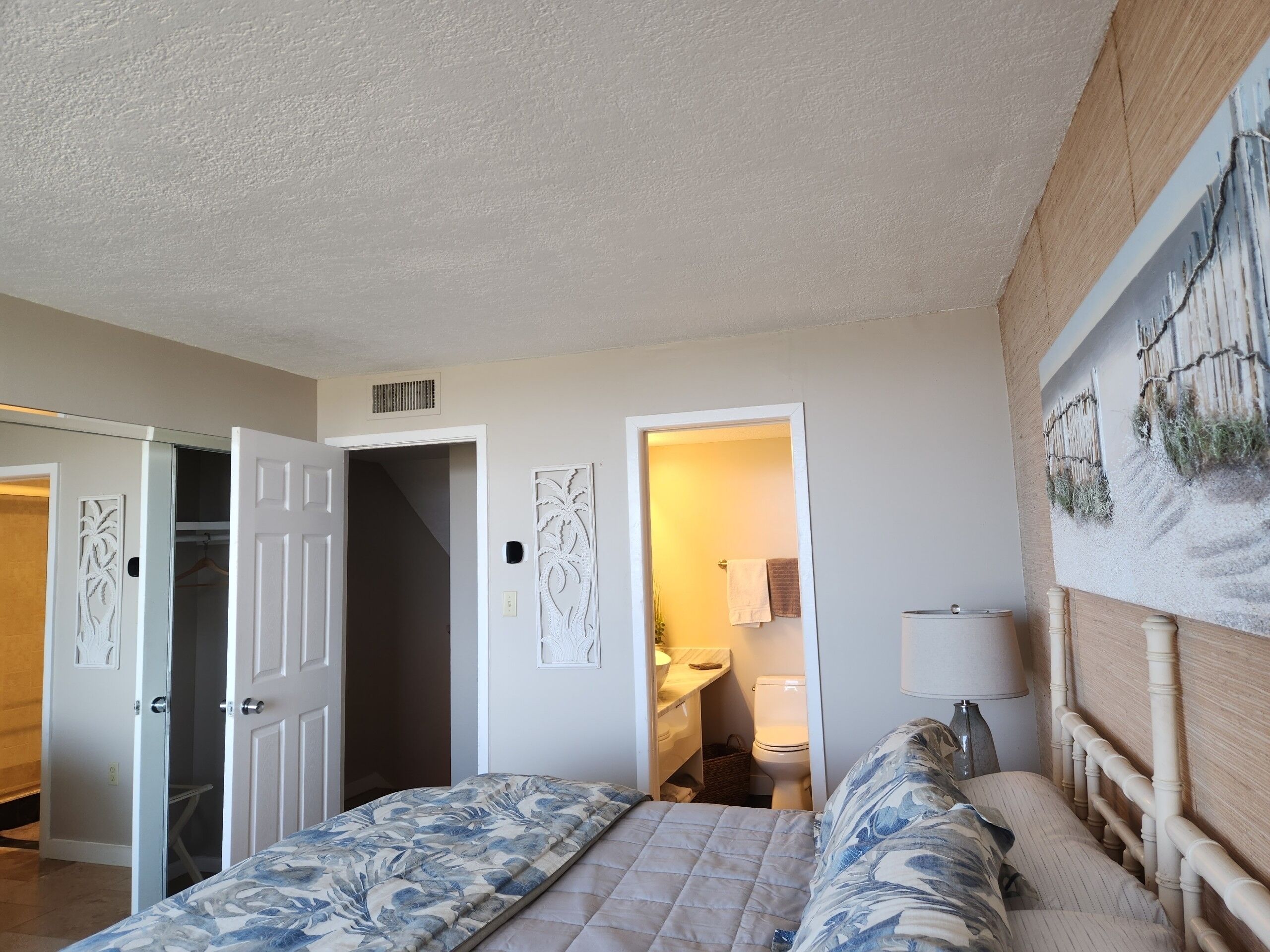 Ein Schlafzimmer mit einem Bett, einem Nachttisch und einem Bild an der Wand.