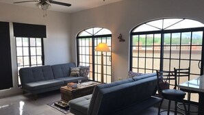Una sala de estar con sofá, una mesa de centro y un comedor con sillas.