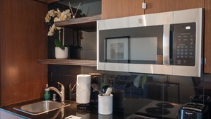 A modern kitchen with stainless steel appliances, a built-in microwave, and a sink.