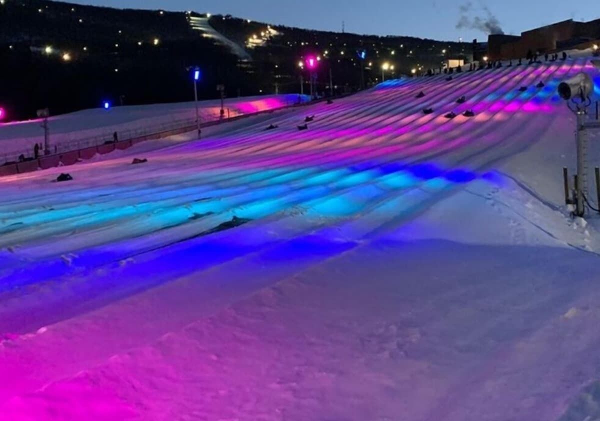 A snow-covered slope with colorful lights.