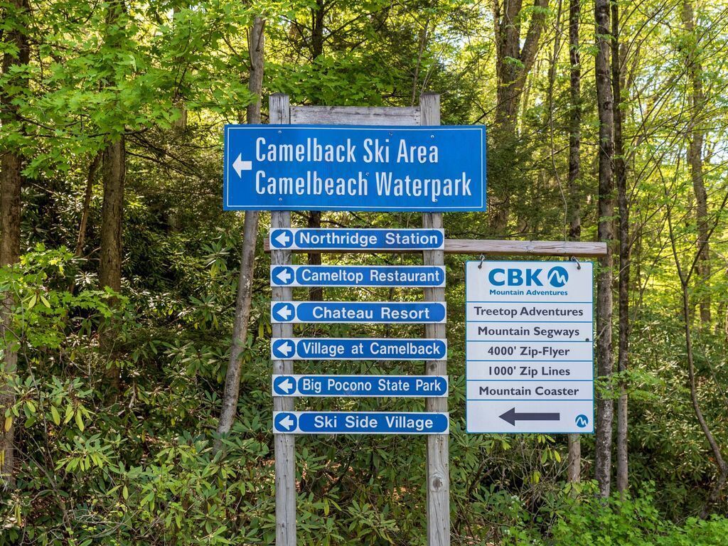 Een richtingwijzer met meerdere pijlen die naar verschillende bestemmingen wijzen, zoals Camelback Ski Area, Camelback Waterpark, Northridge Station, Cameltop Restaurant, Chateau Resort, Village at Camelback, Big Pocono State Park en Ski Side Village.
