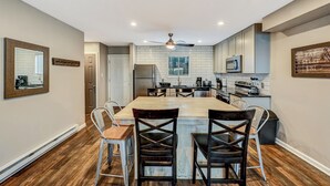 A modern kitchen with a central island, white subway tiles, and stainless steel appliances. - Camelback,Aquatopia/Camelbeach Waterparks,Pool,Tennis,Paintball,Jacuzzi,Zip-Line (Tannersville)