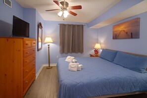 A bedroom with a bed, a dresser, a ceiling fan, a TV, and a painting on the wall. - Gorgeous Direct Oceanfront 2-BR Condo In The 2nd Floor in Broadwalk, Downtown MB (Myrtle Beach)