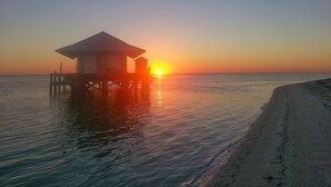 A wooden structure on stilts over water during sunset. - Newly Renovated Island Pool Home
 (Captiva)