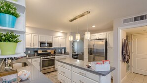 A modern kitchen with white cabinets, stainless steel appliances, and a central island. - Scottsdale 4BR – Heated Pool, Putting Green, 5 Min to Old Town (Scottsdale)