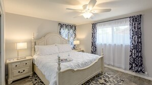 A neatly arranged bedroom with a bed, bedside tables, a ceiling fan, and patterned curtains. - Scottsdale 4BR – Heated Pool, Putting Green, 5 Min to Old Town (Scottsdale)