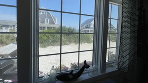 A room with a large window overlooking a beach and houses. - Cottage is on a PRIVATE BEACH shared between two houses.  (East Sandwich)