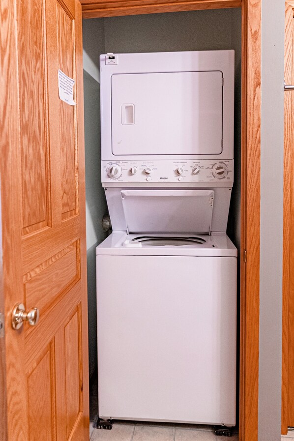 A compact laundry room with a stacked washer and dryer.