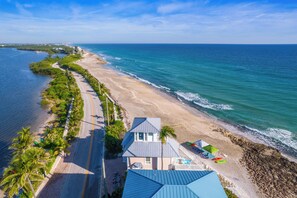 Ein Küsteneigentum mit befestigter Zufahrt, Zugang zum Strand und Blick auf den Ozean.