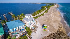 Una propiedad frente al mar con una casa grande, un muelle y una playa de arena.