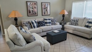 A living room with two sofas, a coffee table, and two lamps. There are two framed pictures on the wall. - Pet-Friendly Fenced Home w/Pool & Spa Heat - 3 Miles from Disney (Kissimmee)