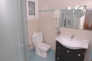 Regadera, secadora de cabello, toallas, papel de baño