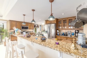 A modern kitchen with granite countertops, stainless steel appliances, and pendant lighting. - 3 Florida side-by-side Beach Houses; Sleeps 50+. Pools, Hot Tubs, Docks ON Beach (Stuart)