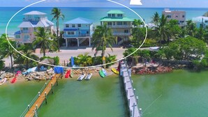 A coastal property with multiple buildings, a dock, and a pier. - 3 Florida side-by-side Beach Houses; Sleeps 50+. Pools, Hot Tubs, Docks ON Beach (Stuart)