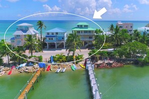 A coastal property with multiple buildings, a dock, and a pier. - 3 Florida side-by-side Beach Houses; Sleeps 50+. Pools, Hot Tubs, Docks ON Beach (Stuart)