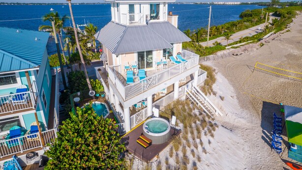 A beachfront property with a pool, lounge chairs, and a hot tub. - 3 Florida side-by-side Beach Houses; Sleeps 50+. Pools, Hot Tubs, Docks ON Beach (Stuart)