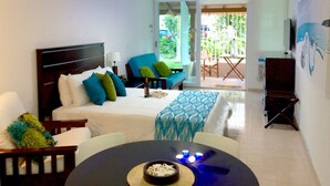 Habitación de hotel con cama, una mesa de comedor con velas, un ventilador de techo y vistas al exterior.