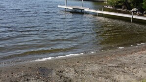 Een rustig meer met een betonnen steiger die in het water reikt.
