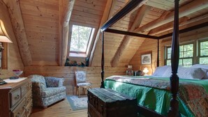 A cozy attic bedroom with a four-poster bed, wooden walls, and a sloped ceiling. - Private log cabin with hot tub and mountain views on 14 acres, pet friendly! (N.Ferrisburgh)