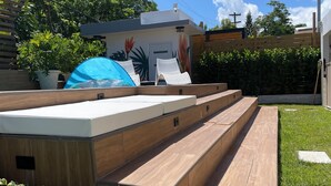 Una terraza moderna al aire libre con asientos integrados y una pequeña zona de piscina.