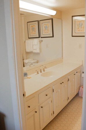 Een bad/douchecombinatie, een haardroger, handdoeken, zeep