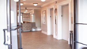 Un couloir comprenant un coin repas, avec une table, des chaises et un meuble décoratif.